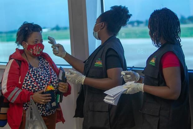 Trabajadores del aeropuerto toman la temperatura y el registro a los pasajeros que llegan el 1 de julio de 2020, al Aeropuerto Internacional Toussaint Louverture de Puerto Príncipe (Haití). 