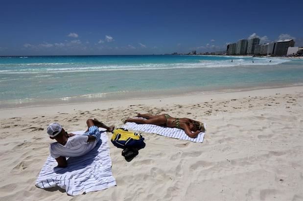 Vista de dos turistas tomando el sol en una playa de Cancún, en el estado de Quintana Roo (México). El Caribe mexicano, con su reconocida zona hotelera de Cancún, se resiente ante el impacto por la pandemia de coronavirus y registró este lunes un 36 % de ocupación, señalaron las autoridades.