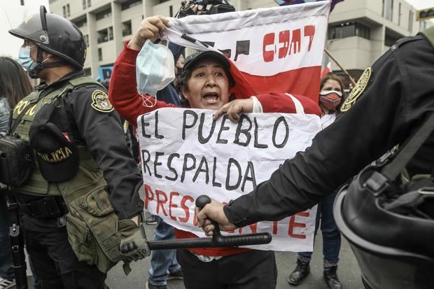 Manifestantes a favor y en contra del Gobierno se enfrentan al exterior del Congreso hoy en Lima.
