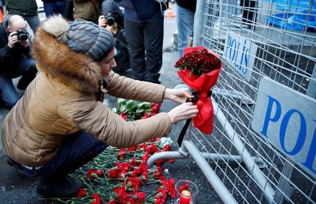 Mujer pone flores en el lugar del incidente. 