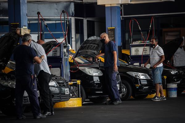 Empleados de una estación de servicio ponen combustible en varios vehículos este jueves, 3 de marzo de 2022, en Buenos Aires (Argentina).