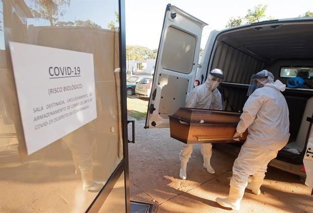 Trabajadores funerarios trasladan víctimas mortales de coronavirus a un lugar separado en el cementerio de Campo da Esperança, en Brasilia, Brasil.
