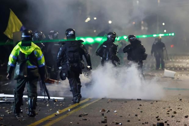 Integrantes del Escuadrón Móvil Antidisturbios (ESMAD) se enfrentan a manifestantes durante una jornada de protestas en Bogotá, Colombia.