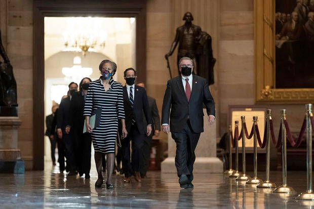 Secretaria de la Cámara Cheryl Johnson (i) junto con el Sargento de Armas Interino Tim Blodgett (d) y el Representante Jamie Raskin (C), dirigir a los gerentes de juicio político de la Cámara Demócrata mientras caminan por el Statuary Hall en el Capitolio.