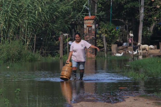 Una mujer camina en medio de una inundación en la comunidad Rancho Chico perteneciente al municipio de Okinawa I en Santa Cruz, Bolivia.
