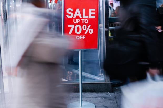 Personas cargan bolsas con sus compras en un centro comercial.