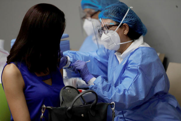 Fotografía de archivo fechada el 19 de enero de 2022 que muestra a una mujer mientras recibe una dosis de la vacuna contra la covid-19, en Ciudad de Panamá.