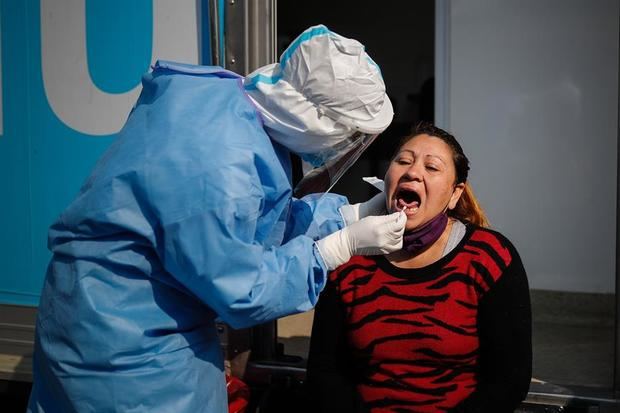 Un trabajador de la salud le practica una prueba para covid-19 a una mujer en la ciudad Villa Fiorito este lunes, en la provincia de Buenos Aires, Argentina.