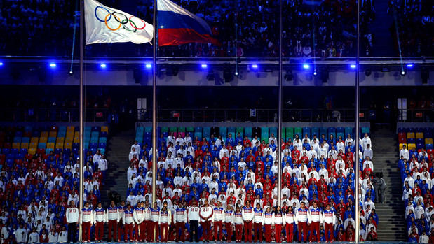 La bandera olímpica y la rusa se izan durante la ceremonia de clausura de los Juegos Olímpicos de Invierno de 2014 en Sochi, Rusia.