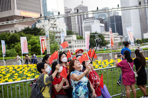 Un grupo de mujeres se toman fotografías mientras sujetan banderas chinas en Hong Kong, China. Un grupo de mujeres se toman fotografías mientras sujetan banderas chinas en Hong Kong, China. 