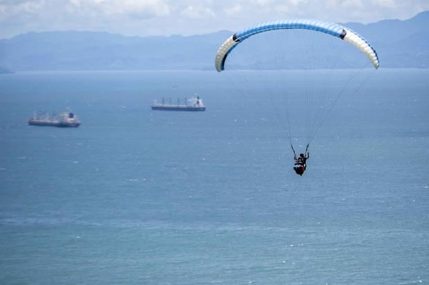 Fotografía del 30 de julio de 2021 de Jean Claude, de nacionalidad suiza y quien fundó en los años 90 de Nemaclys Parapente, junto a una turista realizan un vuelo en Puntarenas.