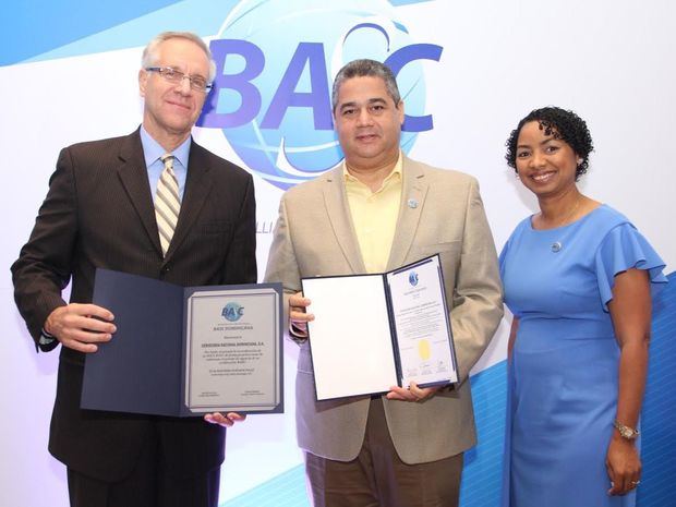 El ministro consejero y encargado de negocios interino de la embajada de los Estados Unidos, Robert Copley y la presidenta de Basc Dominicana, July de la Cruz, entregan las certificaciones de la Cervecería Nacional Dominicana a Carlos Saillant, ejecutiva de esa empresa.