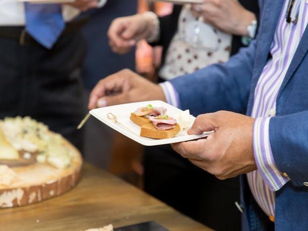 Los presentes disfrutan de los bocadillos.