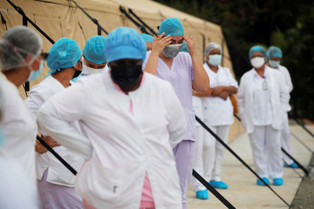 Personal médico del Ministerio de Salud de Panamá (MINSA) se prepara hoy para recibir pacientes con covid-19, en un hospital campaña situado en La Chorrera, Panamá.