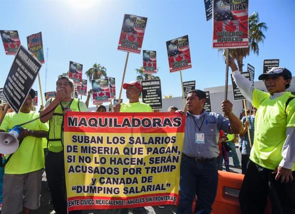 Protesta de un grupo de mexicanos en la frontera con Estados Unidos para reclamar al Gobierno una subida del salario mínimo. 