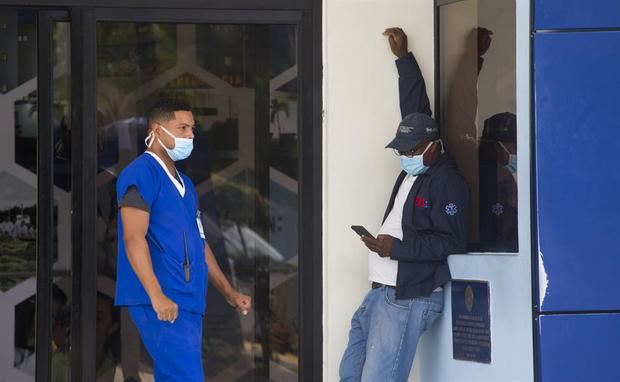 Funcionarios cubiertos con una mascarilla permanecen afuera del hospital militar Ramón de Lara, el cual ha sido debidamente preparado para recibir posibles casos de personas con síntoma de coronavirus, en Santo Domingo, R.D.