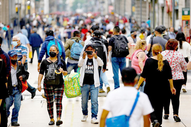 Personas caminan hoy con cubrebocas en el centro de la Ciudad de México, México.