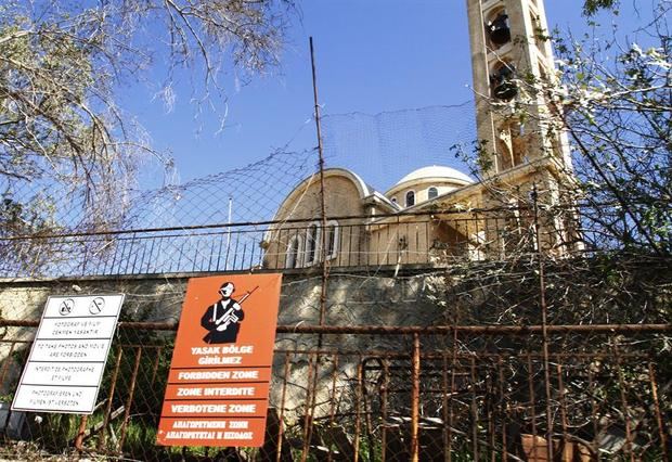 Fachada de una iglesia ortodoxa detrás de una señal militar, en la zona de ocupación turca en la ciudad costera abandonada de Varosha en Famagusta, Chipre.