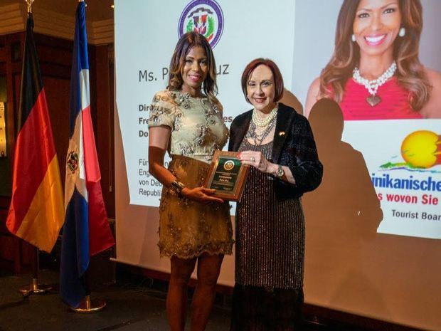Embajadora dominicana en el país europeo, Maibé Altagracia Sánchez Caminero hace entrega del reconocimiento a Petra Cruz.