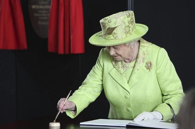 La reina Isabel II de Inglaterra firmaba en el libro de visitantes a su salida de la exposición del Titanic en Belfast, Irlanda del Norte, durante una visita a laregión británca en 2012.
