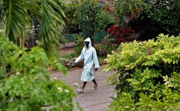 Un hombre con una capa impermeable fue registrado este viernes al caminar bajo la lluvia, en La Habana, Cuba.