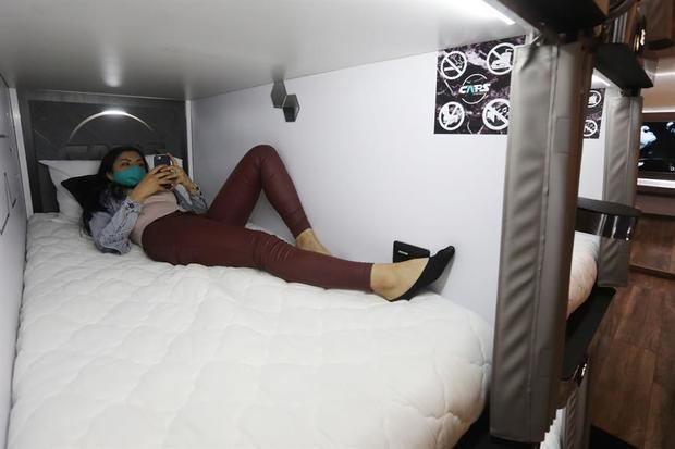 Una mujer descansa en una de las camas del hotel tipo cápsula CAPS Future Rooms el 17 de agosto de 2020, en Bogotá, Colombia.