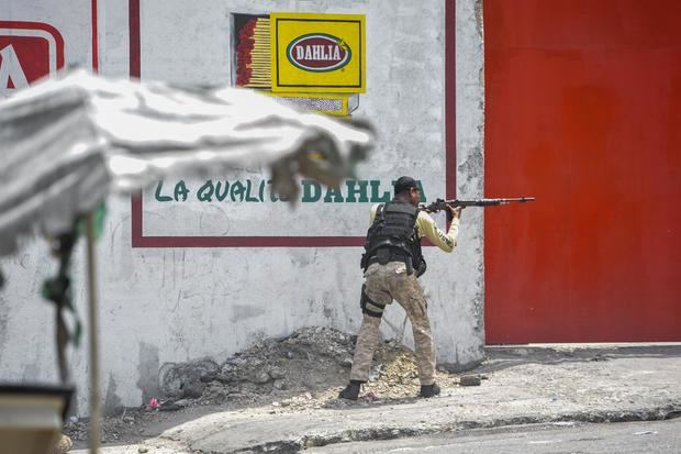Un policía dispara contra manifestantes durante una protesta de ciudadanos para rechazar la inseguridad y los constantes secuestros, hoy, en Puerto Príncipe, Haití.