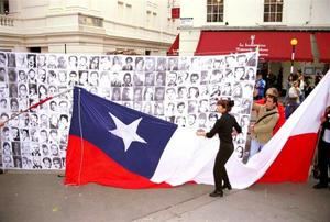 Un grupo de manifestantes colocaba una bandera de Chile junto a un poster con fotos de desaparecido frente a la sede del tribunal de Bow Street en Londres, donde se celebraba la vista sobre la extradición de Pinochet. 