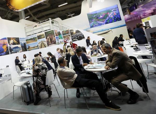 Varias personas visitan un expositor en la Feria Internacional de Turismo de Berlín, Alemania. 