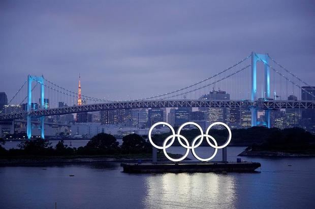 Los aros olímpicos iluminan el agua cerca del Puente del Arco Iris en el Parque Marino de Odiaba, Japón.