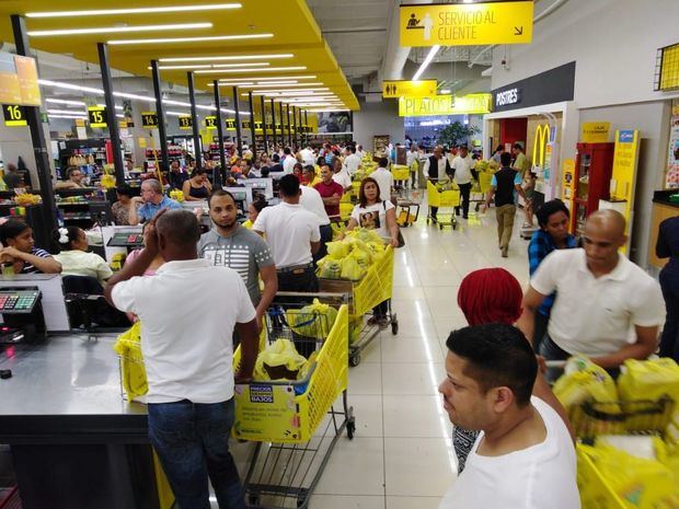 Personas esperando en fila en supermercado.