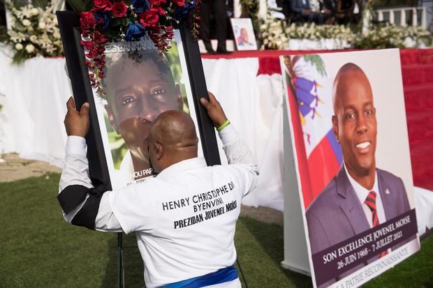 Un hombre besa una imagen del presidente Jovenel Moise durante su ceremonia fúnebre en Cap-Haitien, Haití.