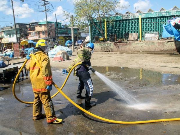 Bomberos durante brigada de limpieza en mecado de la Duarte.