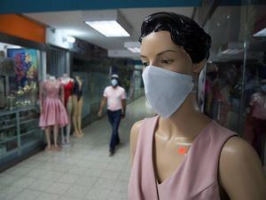 Vista de un maniquí con tapabocas puesto afuera de una tienda de ropa en un centro comercial de la Zona Colonial, en Santo Domingo.