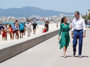 Los reyes pasean por la playa de Palma, inusualmente despoblada por la crisis