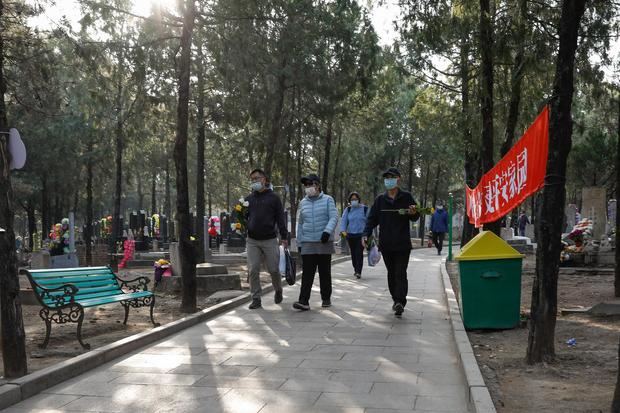 Varias personas que llevan flores y ofrendas buscan las tumbas de sus familiares fallecidos para conmemorar el Festival de Qingming en el Cementerio Popular de Babaoshan en Pekín, China, conocido como el Día de barrido de la tumba.