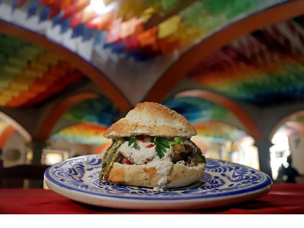 Fotografía de una hamburguesa que lleva los ingredientes del tradicional chile en nogada, en un restaurante de Puebla, México.