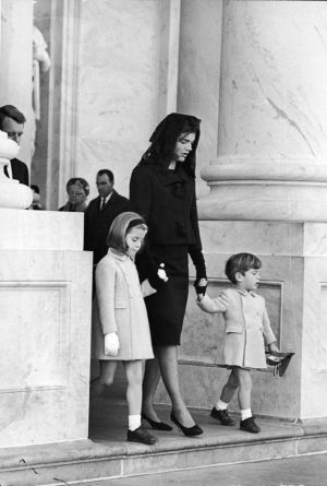 Jacky Kennedy junto a dos de sus hijos saliendo del funeral del presidente Kennedy.