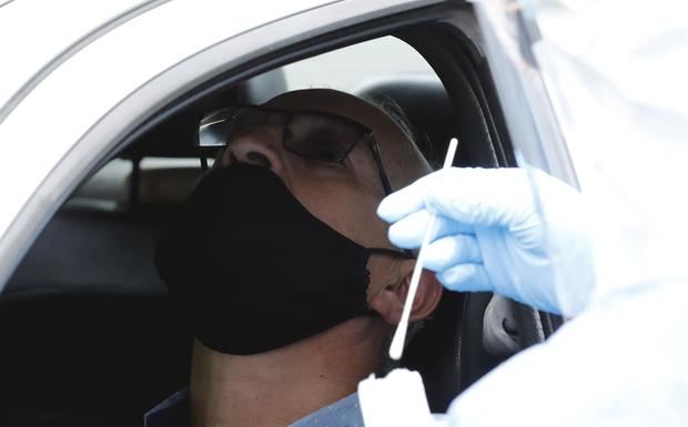 Un hombre espera la toma de una muestra de PCR para SARS Cov-2 en un servicio al auto en Bogotá, Colombia.