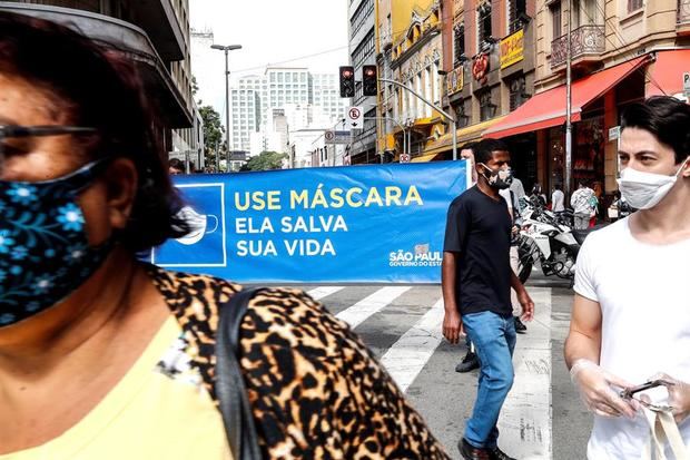 Voluntarios entregan el miércoles 01 de julio de 2020, mascarillas durante una operación de Vigilancia Sanitaria para fiscalizar y advertir sobre el uso obligatorio para prevenir el contagio del COVID-19, en el centro de Sao Paulo (Brasil). 