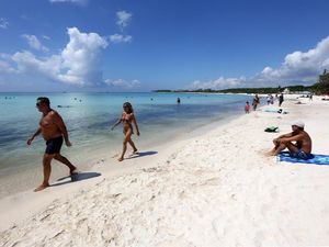 Turistas disfrutan del clima en Playa Punta Esmeralda, hoy jueves en el municipio de Solidaridad, Quintana Roo, México.