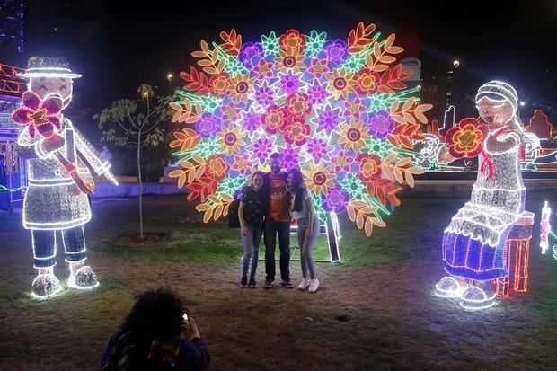 Una familia se toma una fotografía hoy en los tradicionales alumbrados navideños en Medellín, Colombia.