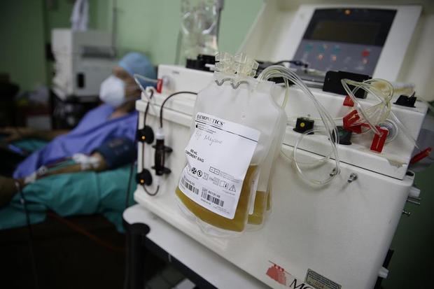 un laboratorista clínico que trabaja en la extracción de plasma de la sangre de un donante recuperado de Covid-19, en el hospital Benjamín Bloom, en San Salvador. 