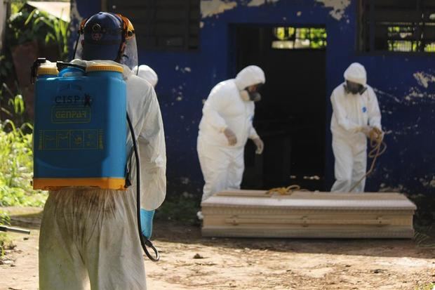 Miembros de Defensa Civil y sepultureros del cementerio municipal de San Cristobal entierran a una persona que falleció por el coronavirus, en San Cristóbal, Venezuela.