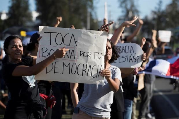 Cientos de jóvenes protestan exigiendo la renuncia de los miembros de la Junta Central Electoral (JCE) frente a la sede del organismo, este lunes, en Santo Domingo.