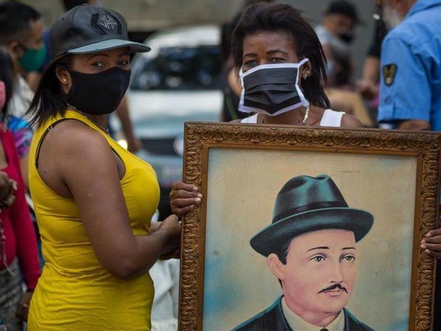 Dos mujeres asisten a la exhumación de los restos de José Gregorio Hernández hoy, en las inmediaciones de la iglesia de Nuestra Señora de La Candelaria, en Caracas, Venezuela.