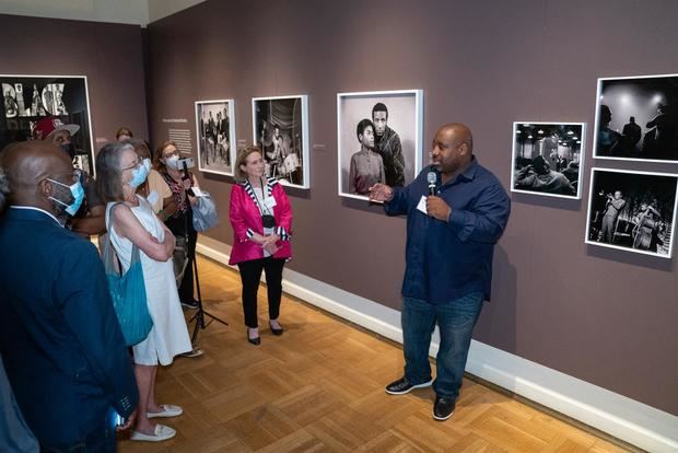 Kwame S. Brathwaite, habla a los asistentes mientras expone sobre una de las obras de su padre, el fotógrafo Kwamw Brathwaite, este 18 de agosto de 2022, durante la muestra fotográfica 'Black is beautiful', en el museo New York Historical Society, en New York, Estados Unidos.
