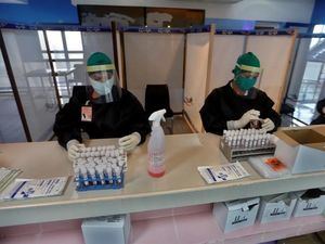 Varias personas con trajes de protección contra el coronavirus revisan el material de trabajo dentro de la zona roja en el aeropuerto internacional Jardines del Rey en Cayo Coco, Cuba. 