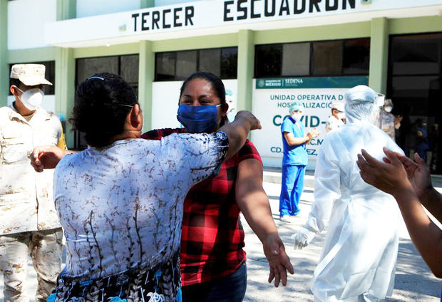 La paciente Adelaida Domínguez (c), de 33 años, abraza a una familiar al salir recuperada de COVID-19 del hospital dentro de la Guarnición Militar del 9no. Regimiento de Caballería Motorizada, en Ciudad Juárez, estado de Chihuahua, México.