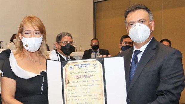 La nueva presidenta del Colegio de Notarios, Laura Sánchez, recibe el certificado de acreditación del presidente de la Comisión Electoral, Juan Moreno Gautreau.